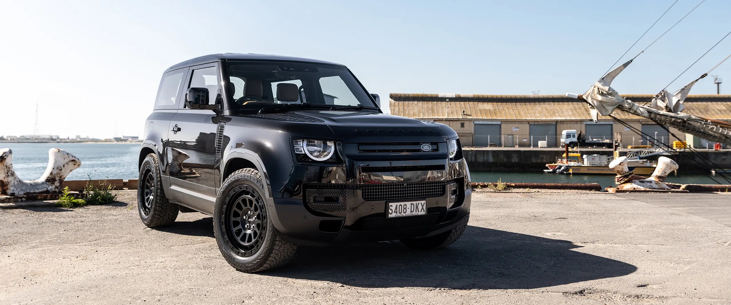 Land Rover Defender 90 fitted with ROH Assault wheels beside a waterfront