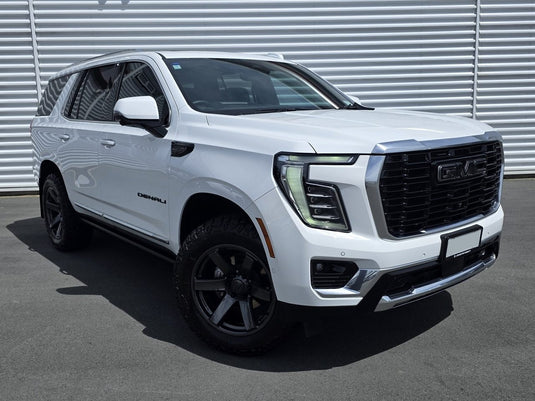 2025 GMC Yukon Denali in Summit White fitted with BGW Beast Gunmetal alloy wheels and Cooper A/T tyres — front three-quarter view