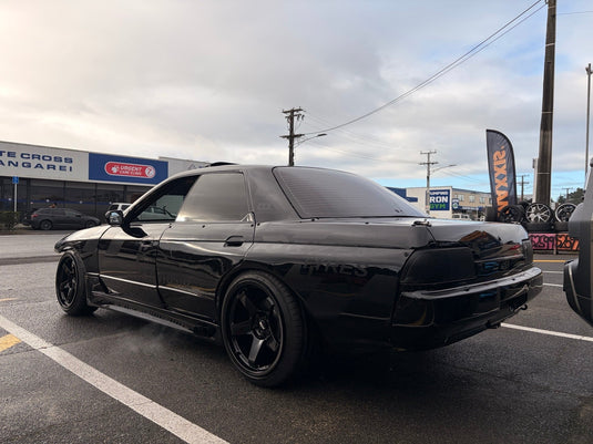 1992 Nissan Skyline R32 GTS-T in Gloss Black with wide-body kit fitted with staggered BGW DC Five Matt Black alloy wheels 18x9.5 ET22 front and 18x10.5 ET22 rear — rear three-quarter view at Orizen Tyres Whangarei