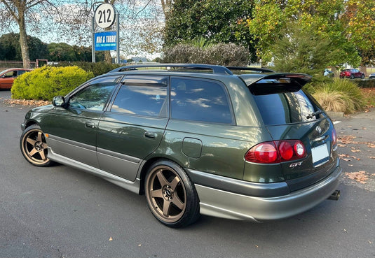 1998 Toyota Caldina GT-T wagon in dark green fitted with BGW DC Five 18x8.5 alloy wheels in Bronze — rear three-quarter view at Mag & Turbo