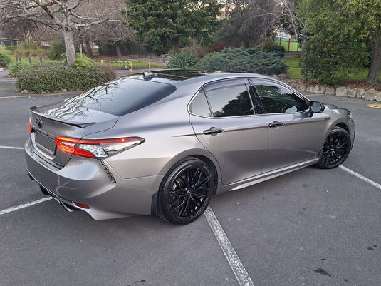 2023 Toyota Camry Hybrid SL in Graphite Grey with lip kit fitted with ROH RF4 Matt Black 19-inch alloy wheels — rear three-quarter view