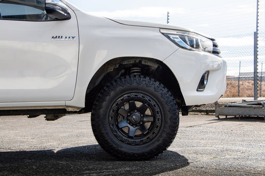 BGW Atlas Matt Black alloy wheel with Tracfour M/T mud-terrain tyre — front wheel arch close-up on 2018 Toyota Hilux SR5 dual cab